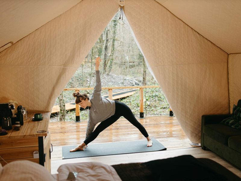 Person performing a flowing yoga sequence in a minimal room